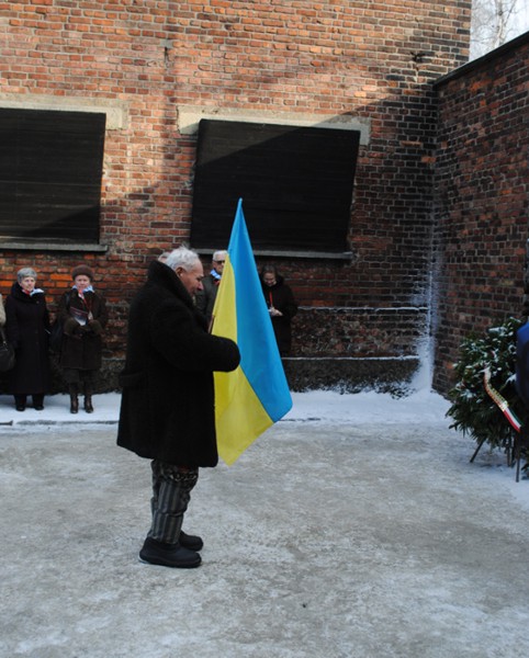 Petro Fedorowicz Miszczuk z flagą Ukrainy na dziedzińcu bloku 11, przed Ścianą Straceń. Fot. wykonano 27.01.2011 r.
